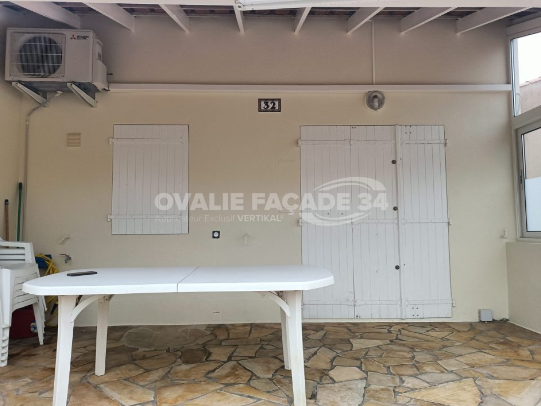 Table blanche sous fenêtre avec volets, façade 34.